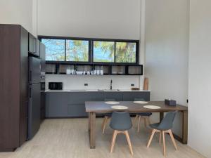 a kitchen with a wooden table and chairs and a kitchen with a counter at Роскошная вилла Lolux Villas in Srithanu
