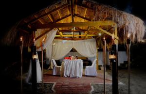 einen Tisch mit weißen Tischdecken in einem Pavillon in der Unterkunft P&M Final Option Beach Resort in San Juan