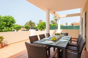 uma mesa preta e cadeiras num pátio em Villa Victoria Paradise em Cala en Blanes