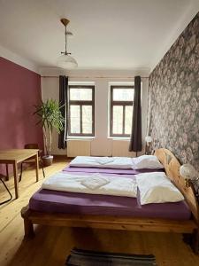 a bedroom with a large bed and a table at Homeplanet Hostel in Leipzig