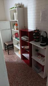 ein rotweißes Bücherregal in einem Zimmer in der Unterkunft Bilocale Del Borgo - SELF CHECKIN H24 in Bologna