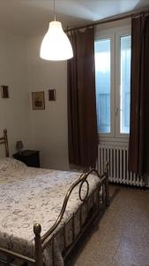 ein Schlafzimmer mit einem Bett und einem großen Fenster in der Unterkunft Bilocale Del Borgo - SELF CHECKIN H24 in Bologna