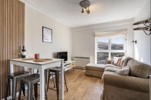 una sala de estar con una mesa y un sofá en Estudio Jimena Alcazaba, en Sierra Nevada