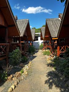 a row of wooden houses with a pathway between them at Benny's House in Pai