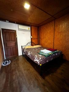 a small bed in a room with a wooden floor at Benny's House in Pai