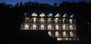 努沃勒埃利耶的住宿－88th Nuwara Eliya，一座大型建筑,晚上有窗户照明