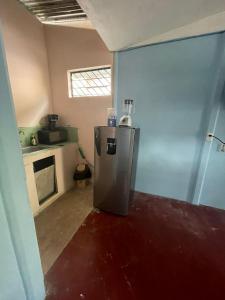 a small refrigerator in a room with a kitchen at Casa Tabacon cr in Río Claro