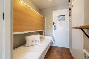 Un dormitorio pequeño con una cama con cabecero de madera. en Estudio Jimena Alcazaba, en Sierra Nevada