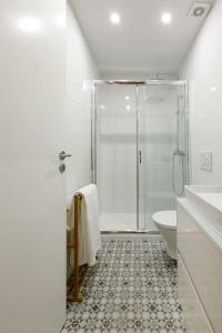 La salle de bains blanche est pourvue d'une douche et de toilettes. dans l'établissement Oporto Cosy Apartment, à Porto