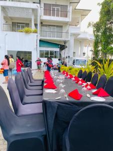 a long black table with red napkins and red napkinsktop at Airport Hotel Dream Paradise in Ja-Ela
