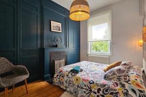 een slaapkamer met een bed, een stoel en een raam bij Maison de Caractère 8 pers - Jardin - in Lambersart