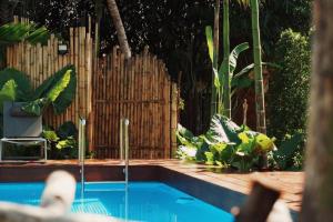 a swimming pool in a garden with a wooden fence at The Canopy Krabi in Ao Nang Beach