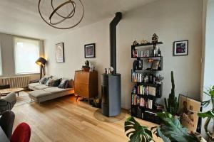 een woonkamer met een bank en een boekenplank bij Maison de Caractère 8 pers - Jardin - in Lambersart