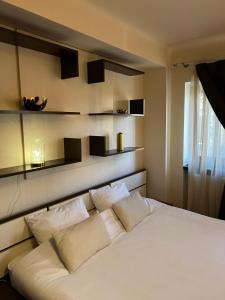 a white bed with four pillows in a room at Urban Oasis: Central Location in Bucharest