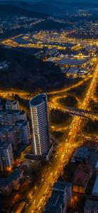 a night view of a city with a tall building at Boudoir Apartment City Tower - 15th floor in Cluj-Napoca