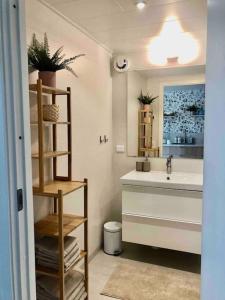 a bathroom with a sink and a toilet and a mirror at Nybyggt boende nära hav och natur. in Störlinge