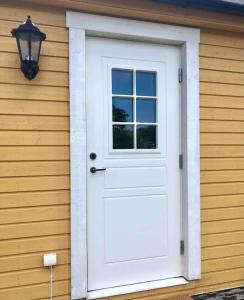 a white door on the side of a house at Nybyggt boende nära hav och natur. in Störlinge