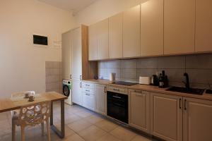 cocina con armarios blancos y mesa de madera en Victoriei Square Apartment en Timişoara