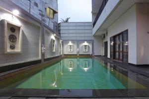 a swimming pool in the middle of a building at ARCS House Pakubuwono by Jambuluwuk in Jakarta