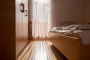 um quarto com uma cama e uma grande janela em Fewo Zweiraum im Haus Götsch 5 em Parcines