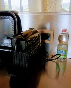 a bottle of water sitting next to a microwave and a bottle at Fonteliving in San Casciano dei Bagni