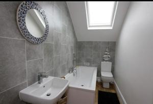 a bathroom with a sink and a mirror and a toilet at Seaglass Cottage - Redcar in Redcar