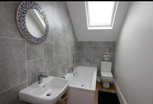 a bathroom with a sink and a mirror and a toilet at Seaglass Cottage - Redcar in Redcar +52 photos