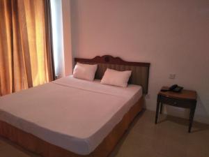 a bedroom with a bed with two pillows and a telephone at Airport Hotel Dream Paradise in Ja-Ela