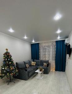 uma sala de estar com uma árvore de Natal e um sofá em Вип em Oral
