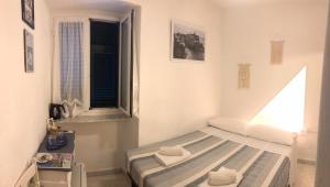 - une petite chambre avec un lit et une fenêtre dans l'établissement Camere Carlo, à Vernazza