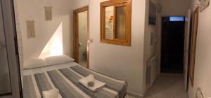 - une chambre avec un lit et un miroir dans l'établissement Camere Carlo, à Vernazza