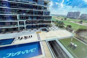 a view of a building with a pool and chairs at Spacious Lux Golf View Apartment in Dubai Marina