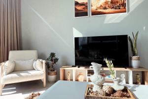 a living room with a tv and a chair and a table at Spacious Lux Golf View Apartment in Dubai Marina