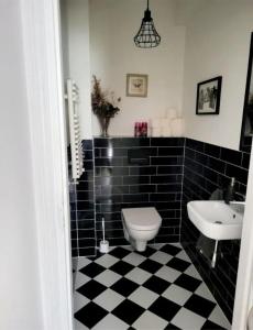 a black and white bathroom with a toilet and a sink at ACH TO TU KARPACZ in Karpacz
