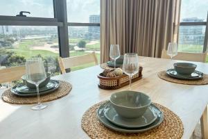 a table with plates and wine glasses on it at Spacious Lux Golf View Apartment in Dubai Marina
