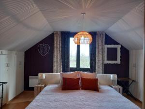 sypialnia z dużym białym łóżkiem i oknem w obiekcie Reve gourmand w mieście Beauraing