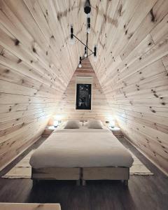 a bedroom with a large bed in a wooden wall at Zibran Cabane in Bran