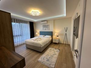 una camera da letto con un letto con testiera blu di Dreams Inn Luxury Residences & Lifestyle a Trabzon