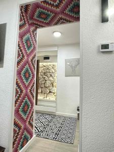 a bathroom with a mirror and a wall with a rug at KOTA - Prime Location in Jahorina
