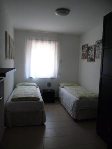 Duas camas num quarto com uma janela em Appartamento Mora em Tenno