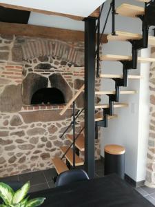 a staircase in a room with a stone oven at Gîte Le four à pain avec SPA in Montmelard