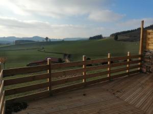 a wooden fence with a view of a green field at Gîte Le four à pain avec SPA in Montmelard