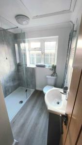 a bathroom with a toilet and a sink and a shower at Comfortable Norfolk Bungalow in Dersingham +7 photos