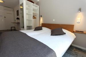- une chambre avec 2 lits et des draps blancs dans l'établissement Hôtel De L'Ill, à Strasbourg