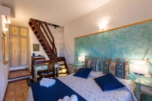 a bedroom with a bed with blue pillows and a staircase at Il Torrione in Castiglione del Lago