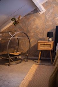 een kamer met een stoel en een tafel met een muur bij Sfeervol Appartement Het Knooppunt in Nuis