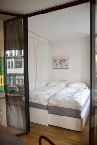 1 dormitorio con 1 cama blanca grande y ventana en Newly produced and bright apartment close to metro, en Solna