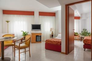 Habitación de hotel con cama, mesa y sillas en 5Miglia Hotel & Spa en Rivisondoli