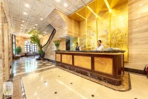 two men standing at a counter in a hotel lobby at Thien Thai Hotel & Spa in Hanoi