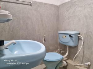 y baño con aseo azul y lavamanos. en Koala Homestay, en Weligama